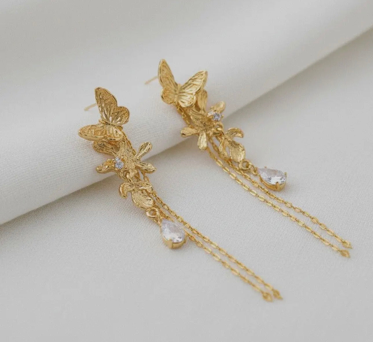 Gold butterfly with chain details in back.